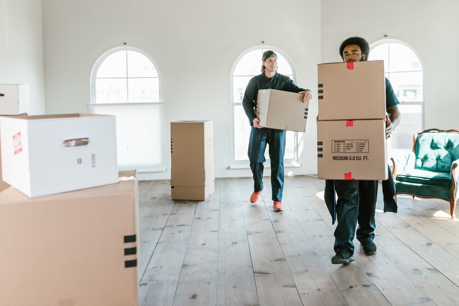 Acme movers carrying boxes during a home move